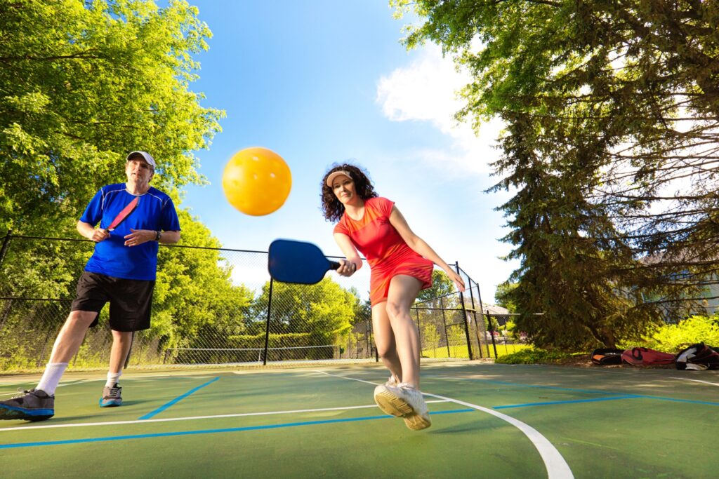 Adults playing pickleball.