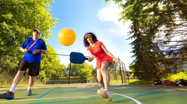 Adults playing pickleball.